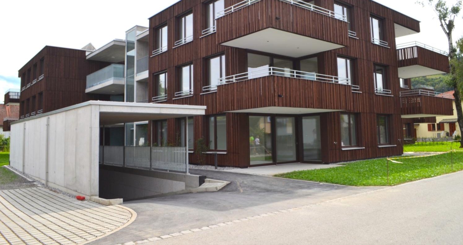 Wohnbau mit dunkler Holzlattenfassade und auskragenden Balkonen